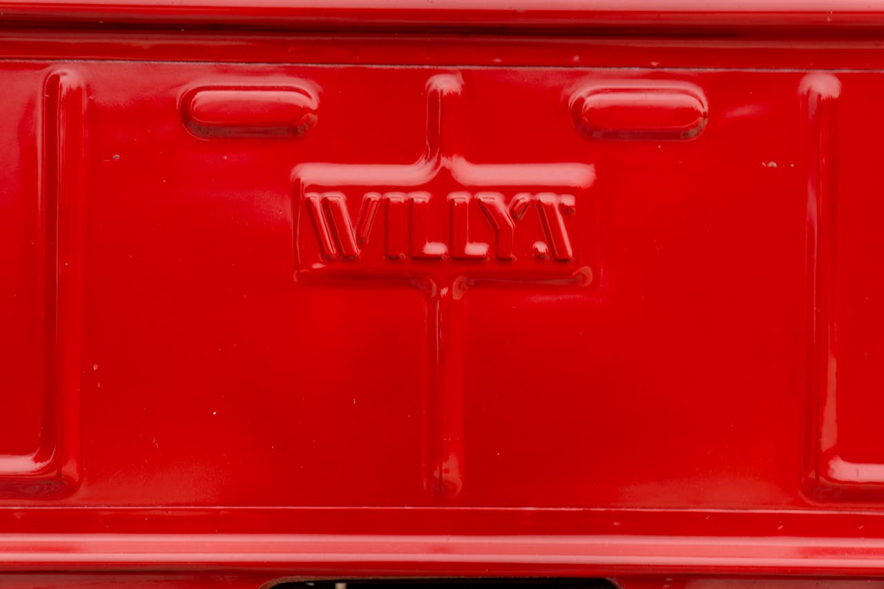 Close-up of red Willys Jeep rear panel, showcasing classic automotive design.