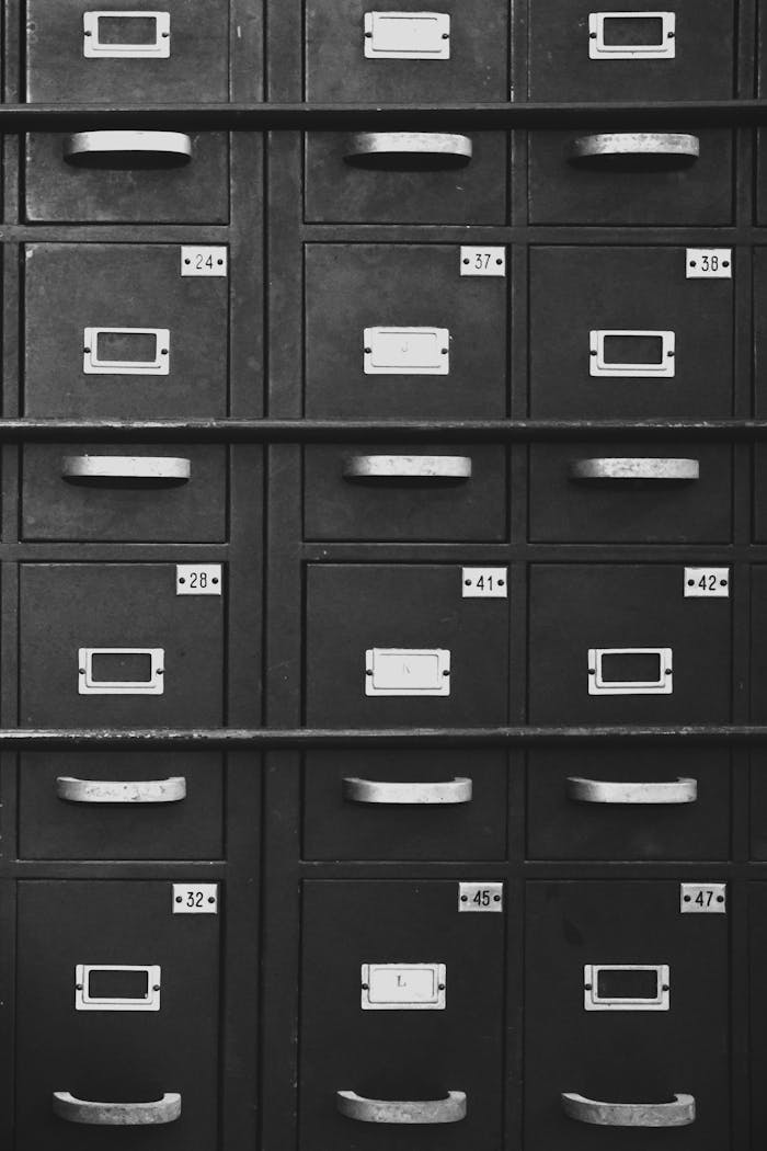 Black and white image of vintage metal filing cabinets with numbers for organizing documents.